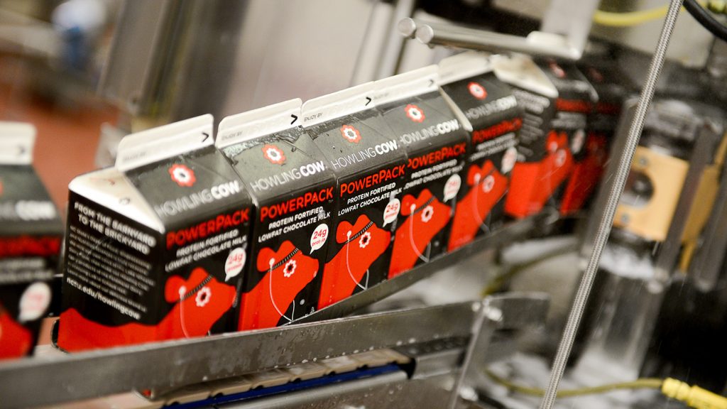 Cartons of PowerPack travel through the packaging process in an NC State food processing facility.